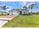 Charming blue home with a well-manicured lawn, brick-paved driveway, and a two-car garage at 7028 N Plum Tree, Punta Gorda, FL 33955