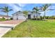 Charming blue home with a well-manicured lawn, brick-paved driveway, and a two-car garage at 7028 N Plum Tree, Punta Gorda, FL 33955