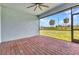 Screened patio with brick floor and ceiling fan overlooks a grassy field at 7028 N Plum Tree, Punta Gorda, FL 33955