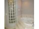Soaking tub with glass block window in a well-lit bathroom, accented with neutral tones at 7500 Ligustrum, Punta Gorda, FL 33955