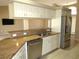 Bright kitchen featuring granite countertops, stainless steel appliances, and white cabinetry at 7500 Ligustrum, Punta Gorda, FL 33955