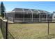 A fenced-in yard features a large screened-in lanai, providing a secure outdoor living space at 7500 Ligustrum, Punta Gorda, FL 33955