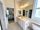 Bathroom view featuring a vanity with double sinks and access to the bedroom at 10900 Lerwick Cir, Englewood, FL 34223