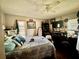 Comfortable bedroom with ceiling fan, a bed with patterned cover, and a dresser with a TV at 1148 Barbour Ave, Port Charlotte, FL 33948