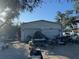 Exterior shot of a metal two-door garage with debris and clutter in the driveway at 1148 Barbour Ave, Port Charlotte, FL 33948