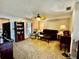 Cozy living room with plush brown carpeting, ceiling fan, and lots of natural light from the large window at 1148 Barbour Ave, Port Charlotte, FL 33948