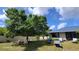 Lush backyard with mature trees, patio furniture, and fenced perimeter at 131 Spring Lake Nw Blvd, Port Charlotte, FL 33952