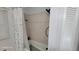 Bathroom with tiled bathtub and shower, white shower curtain, and window at 131 Spring Lake Nw Blvd, Port Charlotte, FL 33952