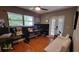 Home office with wood floors, ceiling fan, black accent wall, desk, and white couch at 131 Spring Lake Nw Blvd, Port Charlotte, FL 33952