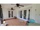 Covered patio with brick floors, multiple ceiling fans, and glass doors to the backyard at 131 Spring Lake Nw Blvd, Port Charlotte, FL 33952