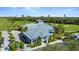 Stunning aerial view of the community clubhouse, featuring beautiful landscaping, golf courses, and parking areas at 14281 Heritage Landing Blvd # 1418, Punta Gorda, FL 33955