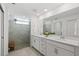 Bathroom with double vanity, large mirror, and a glass-enclosed shower and linen closet at 14281 Heritage Landing Blvd # 1418, Punta Gorda, FL 33955