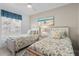 Charming bedroom featuring two twin beds with floral bedding and beach-themed decor at 14281 Heritage Landing Blvd # 1418, Punta Gorda, FL 33955