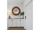 Bright entryway with a woven mirror, lamp, white cabinets, and a plant in a vase at 14281 Heritage Landing Blvd # 1418, Punta Gorda, FL 33955