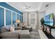 Cozy living room features a plush gray sofa, accent wall, and entertainment center with TV at 14281 Heritage Landing Blvd # 1418, Punta Gorda, FL 33955