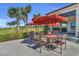 Charming outdoor dining area with tables, chairs, and umbrellas, offering a scenic view of lush landscape at 14281 Heritage Landing Blvd # 1418, Punta Gorda, FL 33955