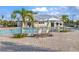 Community pool area with lounge chairs, umbrellas, and palm trees on a sunny day at 14281 Heritage Landing Blvd # 1418, Punta Gorda, FL 33955