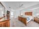Spacious bedroom featuring a ceiling fan, carpet, and a large wooden bed and dresser set at 15538 Aqua Cir, Port Charlotte, FL 33981