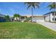 Charming single-Gathering home with a well-manicured lawn, lush palm trees and a two-car garage at 15538 Aqua Cir, Port Charlotte, FL 33981