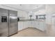 Kitchen features a stainless steel refrigerator, granite counters, and white cabinets at 15538 Aqua Cir, Port Charlotte, FL 33981