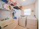 Functional laundry room with white washer and dryer, utility sink, and shelving for storage at 15538 Aqua Cir, Port Charlotte, FL 33981