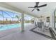 Covered lanai with ceiling fans and seating area overlooking the sparkling pool and waterway at 15538 Aqua Cir, Port Charlotte, FL 33981