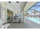 Spacious covered lanai with ceiling fans, outdoor seating, and stunning waterfront and pool views at 15538 Aqua Cir, Port Charlotte, FL 33981