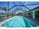 Inviting pool with screened-in enclosure offering picturesque waterfront views and outdoor seating area at 15538 Aqua Cir, Port Charlotte, FL 33981