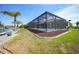 Outdoor living with a screened pool enclosure set on a well-maintained backyard along a canal at 15538 Aqua Cir, Port Charlotte, FL 33981
