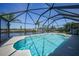 Sparkling blue pool with screened enclosure and beautiful waterfront views, ideal for relaxation and entertainment at 15538 Aqua Cir, Port Charlotte, FL 33981