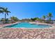 Community pool with clear blue water, palm trees, and deck chairs surrounded by patterned brickwork at 2001 Bal Harbor Blvd # 2312, Punta Gorda, FL 33950