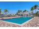 Community pool area featuring a spacious deck, comfortable lounge chairs, and beautiful palm trees at 2001 Bal Harbor Blvd # 2312, Punta Gorda, FL 33950