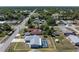 Aerial view of a home with a screened-in pool in a neighborhood close to roads and surrounded by trees at 21168 Quesada Ave, Port Charlotte, FL 33952