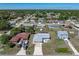 Aerial view of a residential area with a gray house, screened pool, and long driveway at 21168 Quesada Ave, Port Charlotte, FL 33952