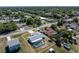 Expansive aerial view of a well-maintained property featuring a screened pool, fenced yard, and lush surrounding landscape at 21168 Quesada Ave, Port Charlotte, FL 33952