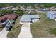 Aerial view of a home with a screened pool and a long driveway surrounded by green spaces at 21168 Quesada Ave, Port Charlotte, FL 33952