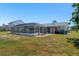 Spacious backyard with a screened-in pool, providing ample room for outdoor activities and relaxation at 21168 Quesada Ave, Port Charlotte, FL 33952