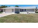 Charming single-story home featuring a well-maintained lawn, attached garage and manicured landscaping at 21168 Quesada Ave, Port Charlotte, FL 33952