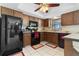 View of the kitchen with dark cabinets, black appliances, tile flooring, and a bright window at 21168 Quesada Ave, Port Charlotte, FL 33952