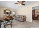Living room showcasing neutral carpet, ceiling fan, and sitting area with view to kitchen at 21168 Quesada Ave, Port Charlotte, FL 33952