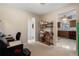 Bright office space with neutral paint, carpet, a desk area, shelves, and access to the kitchen at 21168 Quesada Ave, Port Charlotte, FL 33952