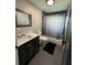Bathroom featuring tiled floor, a modern vanity, and shower-tub combination with neutral shower curtain at 22223 Seyburn Ter, Port Charlotte, FL 33954