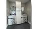 Modern bathroom showcasing dual vanities, round mirrors, and stylish sliding cabinet doors at 22223 Seyburn Ter, Port Charlotte, FL 33954