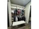 Organized walk-in closet featuring custom shelving, clothing racks, and a comfortable bench at 22223 Seyburn Ter, Port Charlotte, FL 33954
