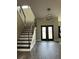Elegant foyer featuring a modern chandelier, staircase, and stylish black double doors at 22223 Seyburn Ter, Port Charlotte, FL 33954
