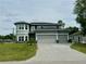Stunning two-story home featuring a three-car garage, well-manicured lawn, and a brick-paved driveway at 22223 Seyburn Ter, Port Charlotte, FL 33954