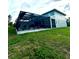 A rear view of the enclosed pool and surrounding yard offers serene outdoor space at 22223 Seyburn Ter, Port Charlotte, FL 33954