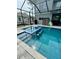 Screened in pool with integrated spa, stepping stools, and a storage closet at 22223 Seyburn Ter, Port Charlotte, FL 33954