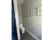 Modern powder room with gray tile floor, updated toilet, and geometric artwork at 22223 Seyburn Ter, Port Charlotte, FL 33954