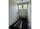 Modern staircase with dark steps and black railings, leading down to a lower level at 22223 Seyburn Ter, Port Charlotte, FL 33954